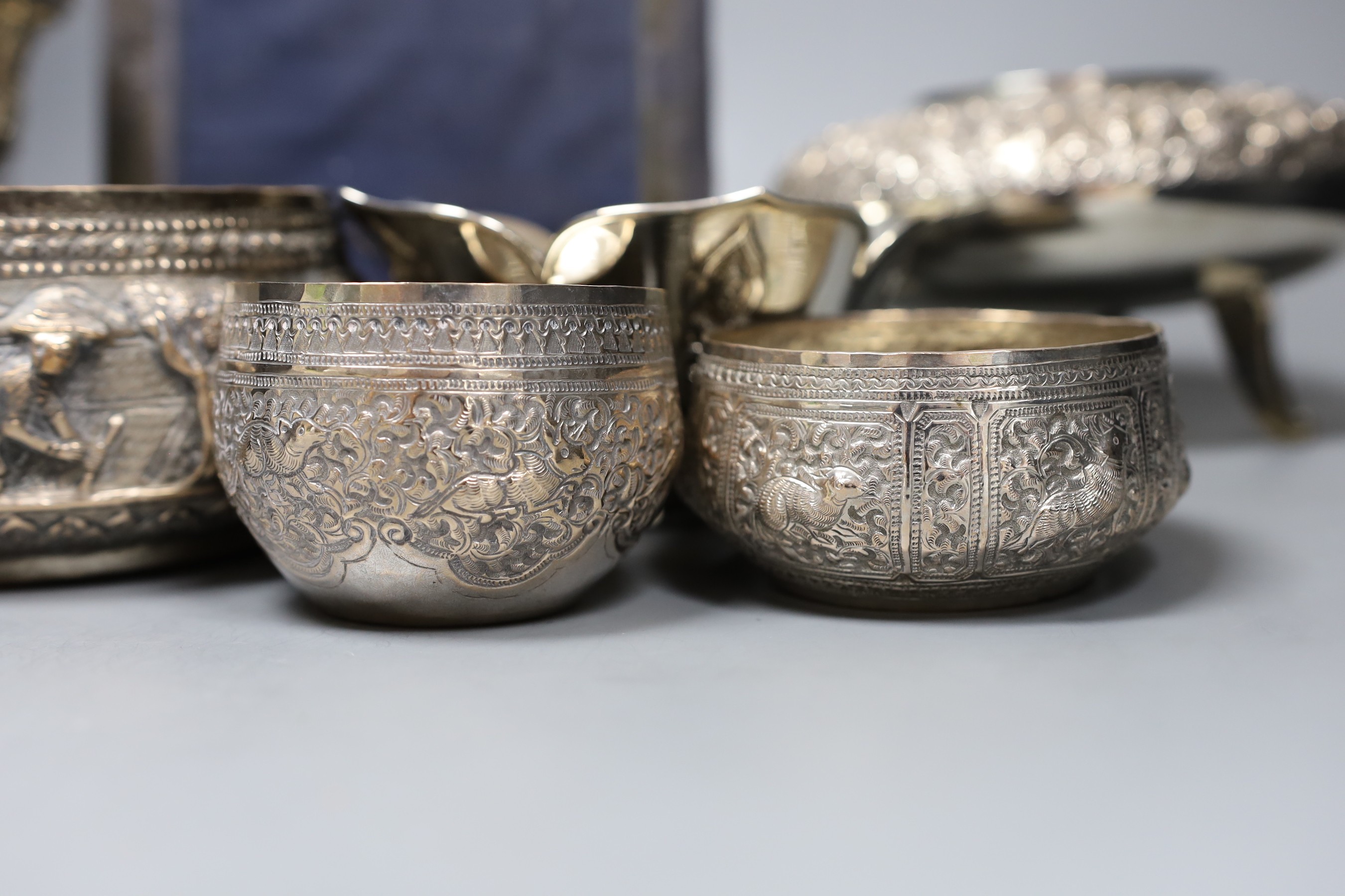 Six assorted embossed Thai white metal bowls, largest 18cm diam., and a silver photograph frame